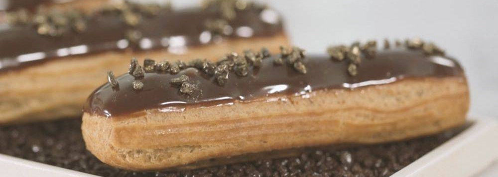 Chocolate-glazed pastries with chocolate crumb topping on a white plate.